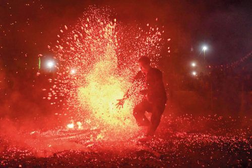 Ein Mann der ethnischen Pa Then-Gruppe Vietnams, springt während eines Feuertanzrituals in der Provinz Tuyen Quang auf brennenden Kohlen umher. Die Pa Then glauben, dass dieses traditionelle Ritual dabei helfen kann, Dämonen auszutreiben. AFP