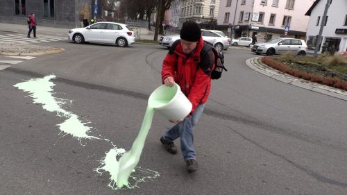 Ein Aktivist der „Extinction Rebellion“ beim Ausschütten der grünen Kreidefarbe auf dem Kreisverkehr auf der Reichsstraße.  M. shourot