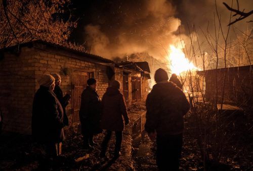 Nach einem russischen Angriff in Tschassiw Jar in der Provinz Donezk stehen Anrainer vor einem brennenden Haus. Reuters