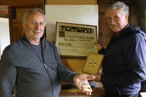 Friedrich Vögel und Erich Schwärzler präsentierten Sutterlütys Ehrenurkunde und aus Holz gefertigte Eintrittskarten sowie Vögels erste Tischlerarbeit.