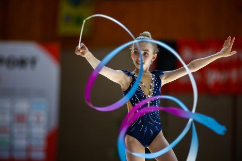 Elina Loacker gewann in der Jugend-1-Klasse Gold mit dem Reifen und holte Silber im Mehrkampf, mit dem Band und in der Mannschaft. Turnsport Austria/Fassbender