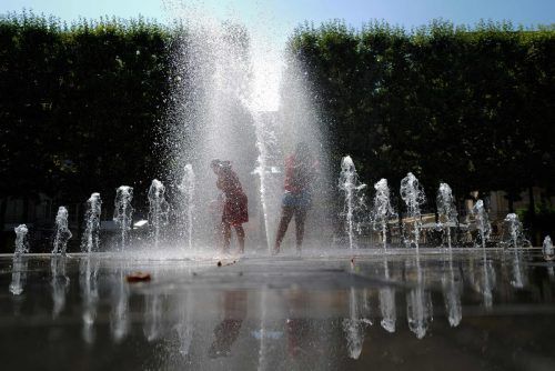 Während der Hitzewelle in Montpellier, Südfrankreich, kühlen sich Kinder in einem Brunnen unter Wasserstrahlen ab. AFP