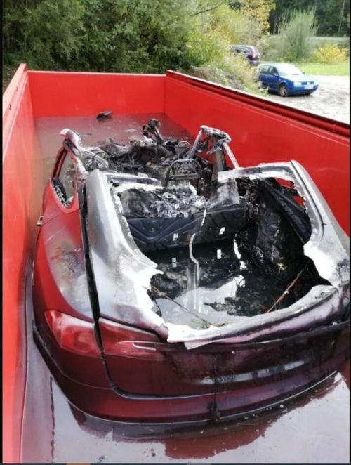 Ausgebrannter Tesla in einer Havarie-Mulde (Löschcontainer), hier bei der Feuerwehr Schwaz in Tirol. FEUERWEHR SCHWAZ