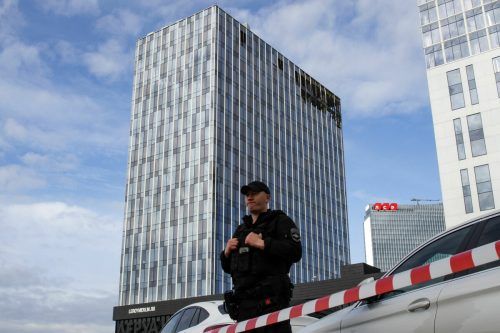 Ein Polizist steht vor einem beschädigten Geschäftszentrum Wache.  AFP