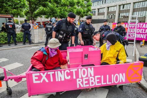 Einbetoniert auf einem 400 Kilogramm schweren "Boot": Die Klimaaktivisten von "Extinction Rebellion" vor dem Landhaus. VN/Steurer