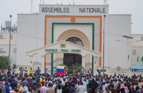 Unterstützer des Putsches versammeln sich vor der Nationalversammlung in Niamey. Auch eine russische Flagge ist zu sehen. AP