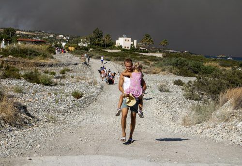 Urlauber und Einheimische suchen am Wasser Schutz vor den Flammen. AP