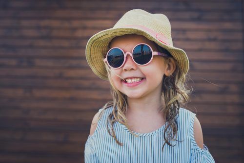 Zusätzlich zur Sonnenbrille ist auch ein schützender Hut bei Kindern ratsam.