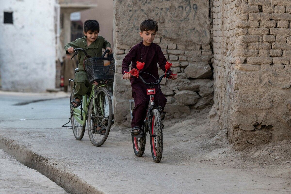 Buben fahren mit dem Fahrrad am Straßenrand von Darwaze Lawry im alten Teil der afghanischen Hauptstadt Kabul entlang. AFP