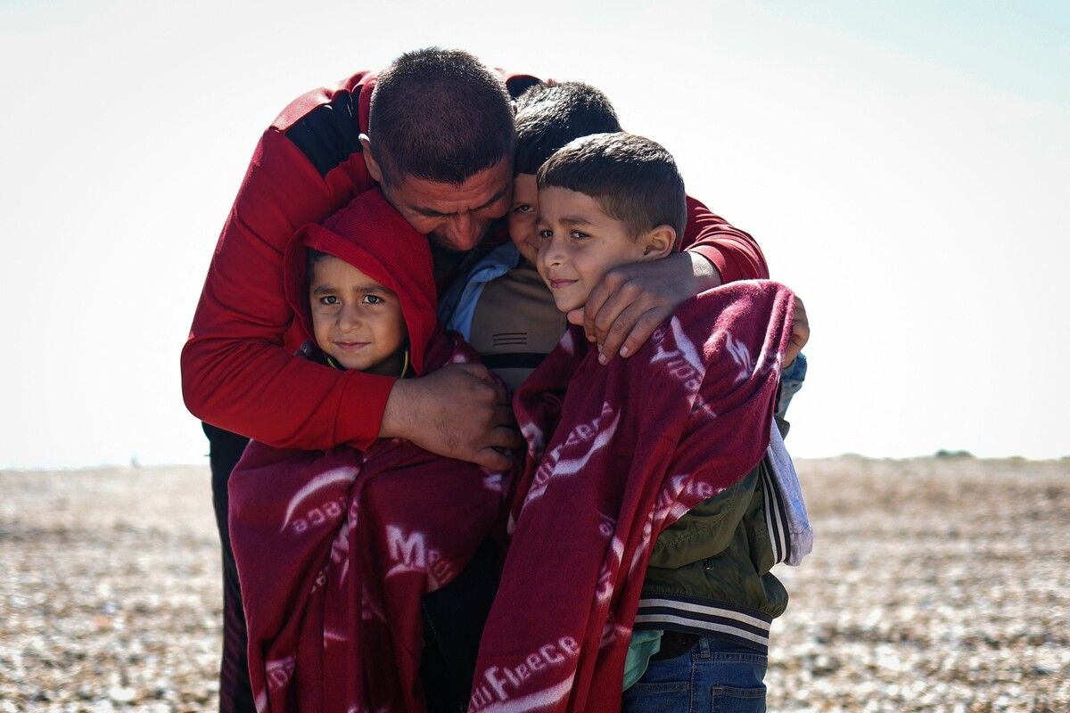 Ein Mann hält am Strand von Dungeness in Südostengland drei Kinder in den Armen. Mehr als 100.000 Migranten haben den Ärmelkanal auf kleinen Booten von Frankreich nach Südostengland überquert, seit Großbritannien 2018 begann, die Ankünfte öffentlich zu registrieren. AFP
