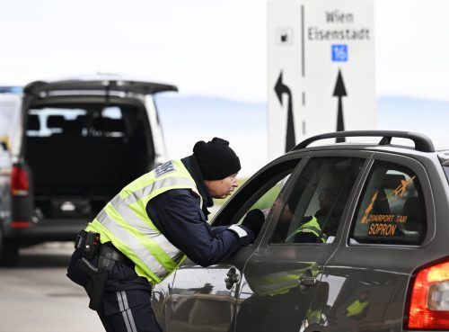 Ein Polizist kontrolliert im Burgenland ein Fahrzeug an der österreichisch-ungarischen Grenze.   APA/Jäger