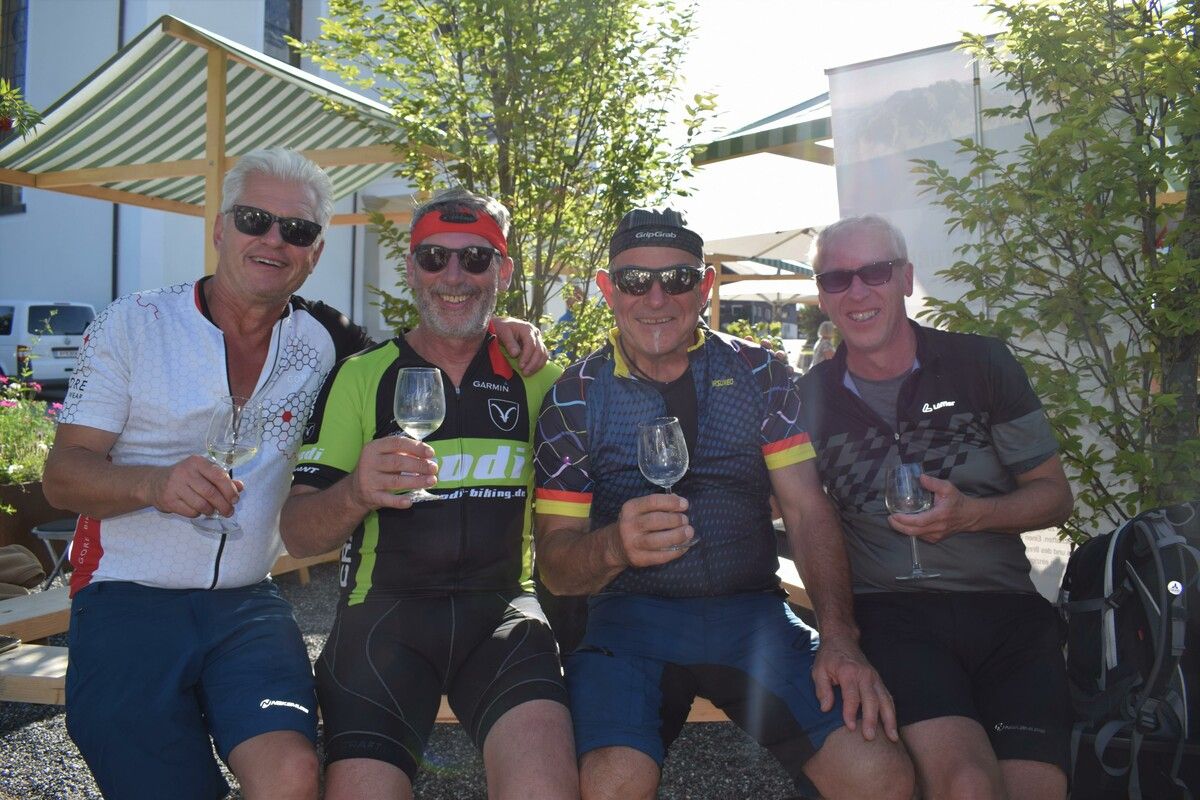 Ein Radler-Quartett genießt die Rast auf dem Dorfplatz.