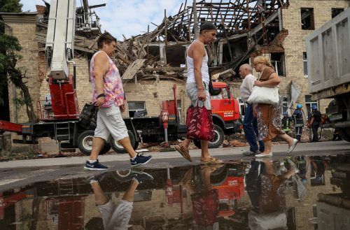Einwohner der ukrainische Stadt Charkiw gehen an einem durch einen russischen Drohnenangriff zerstörten Gebäude vorbei. Reuters