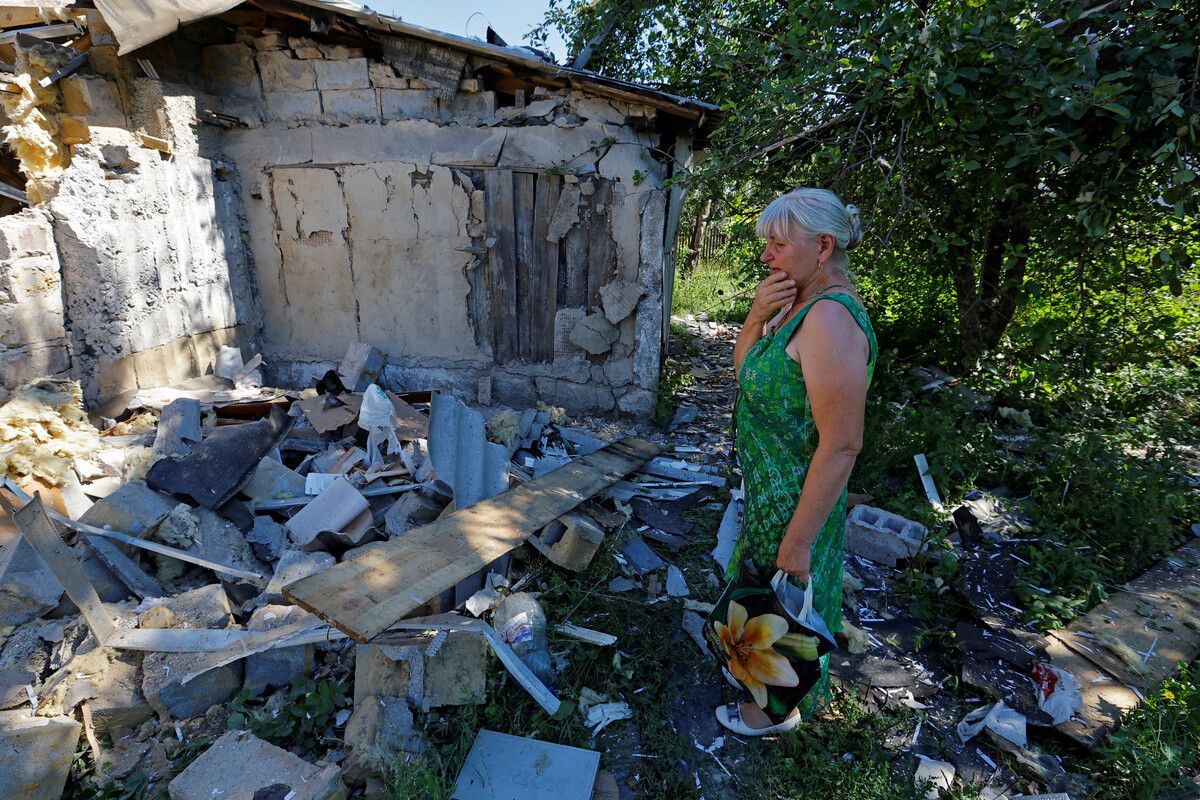 Ljubow Toltschina  (63) steht neben dem beschädigten Haus ihres Sohnes Witali (40) in Donezk, der am Vortag durch Granatenbeschuss getötet wurde. Reuters