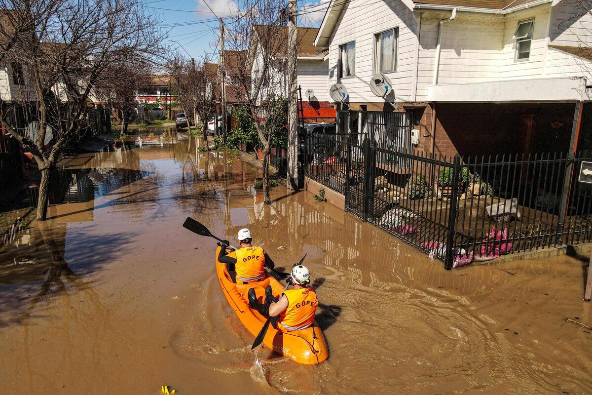 Retter fahren nach heftigen Regenfällen in Santa Cruz, Chile, mit einem Kajak auf einer überfluteten Straße. AFP