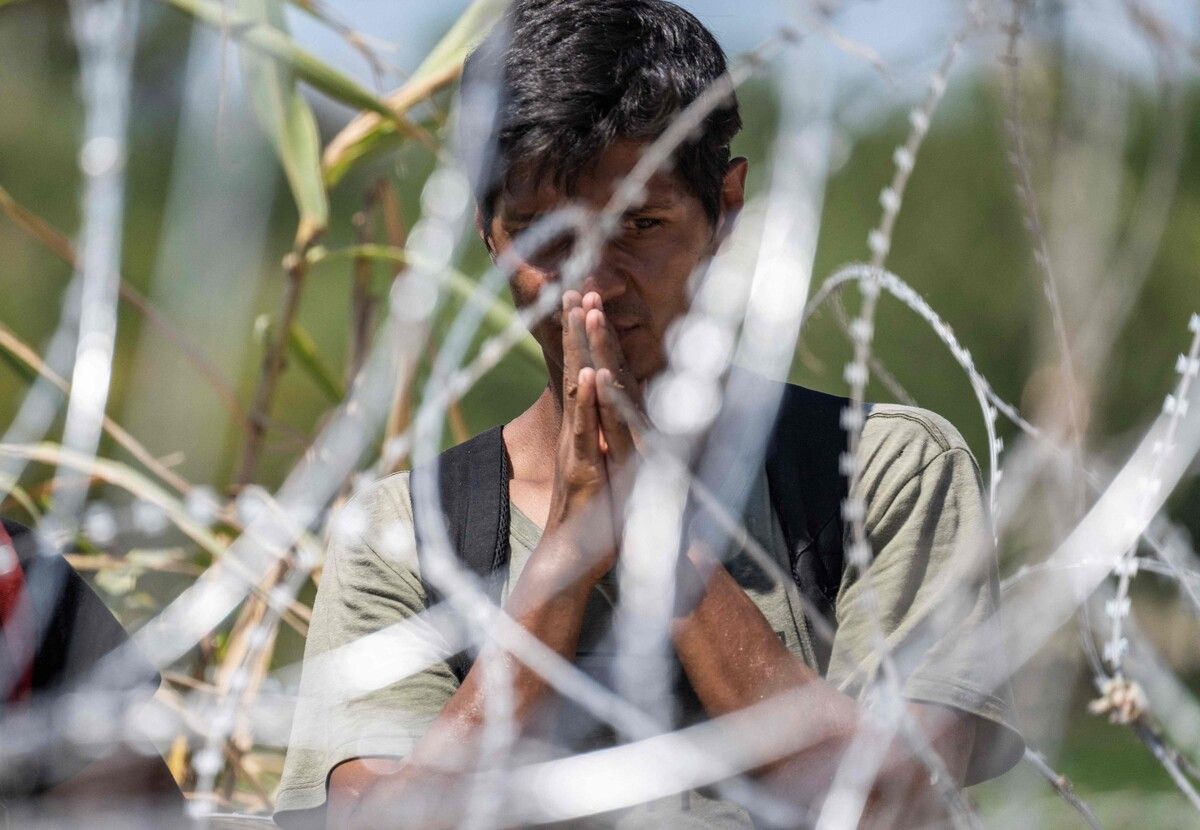 Ein Migrant aus Venezuela betet hinter Stacheldraht, nachdem er den Rio Grande auf dem Weg nach Texas überquert hat. AFP
