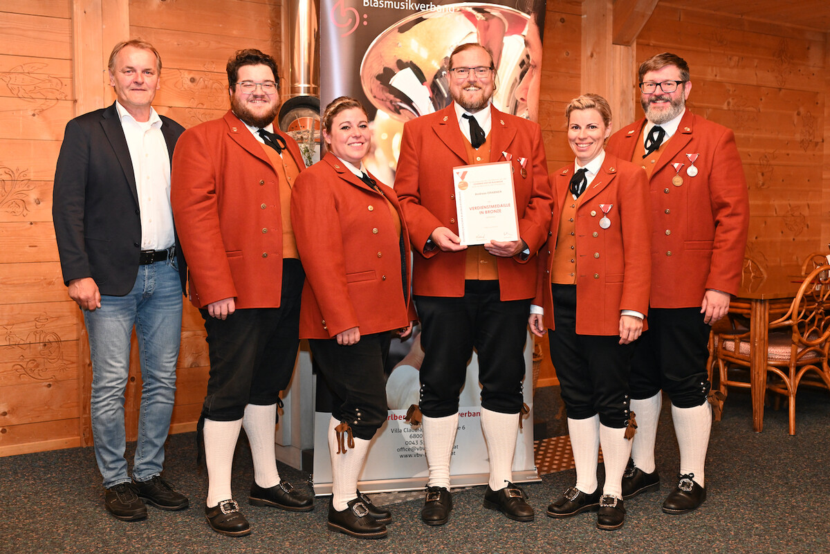 Der Jubilar Andreas Grabner (M.) mit Bürgermeister Georg Bucher sowie Musikkolleginnen und Musikkollegen.blasmusikbezirk bludenz