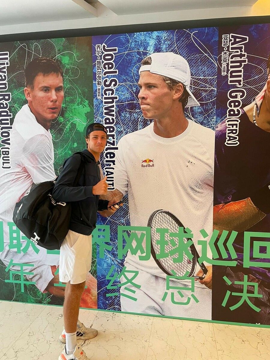 Joel Schwärzler vor seinem Konterfei bei den ITF World Finals in China.ÖTV