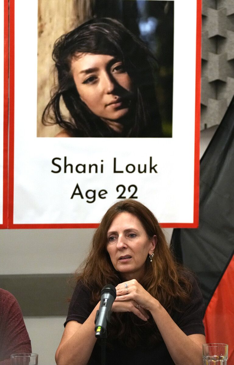Ricarda Louk vor einem Plakat, das ihre 22-jährige Tochter zeigt. AP