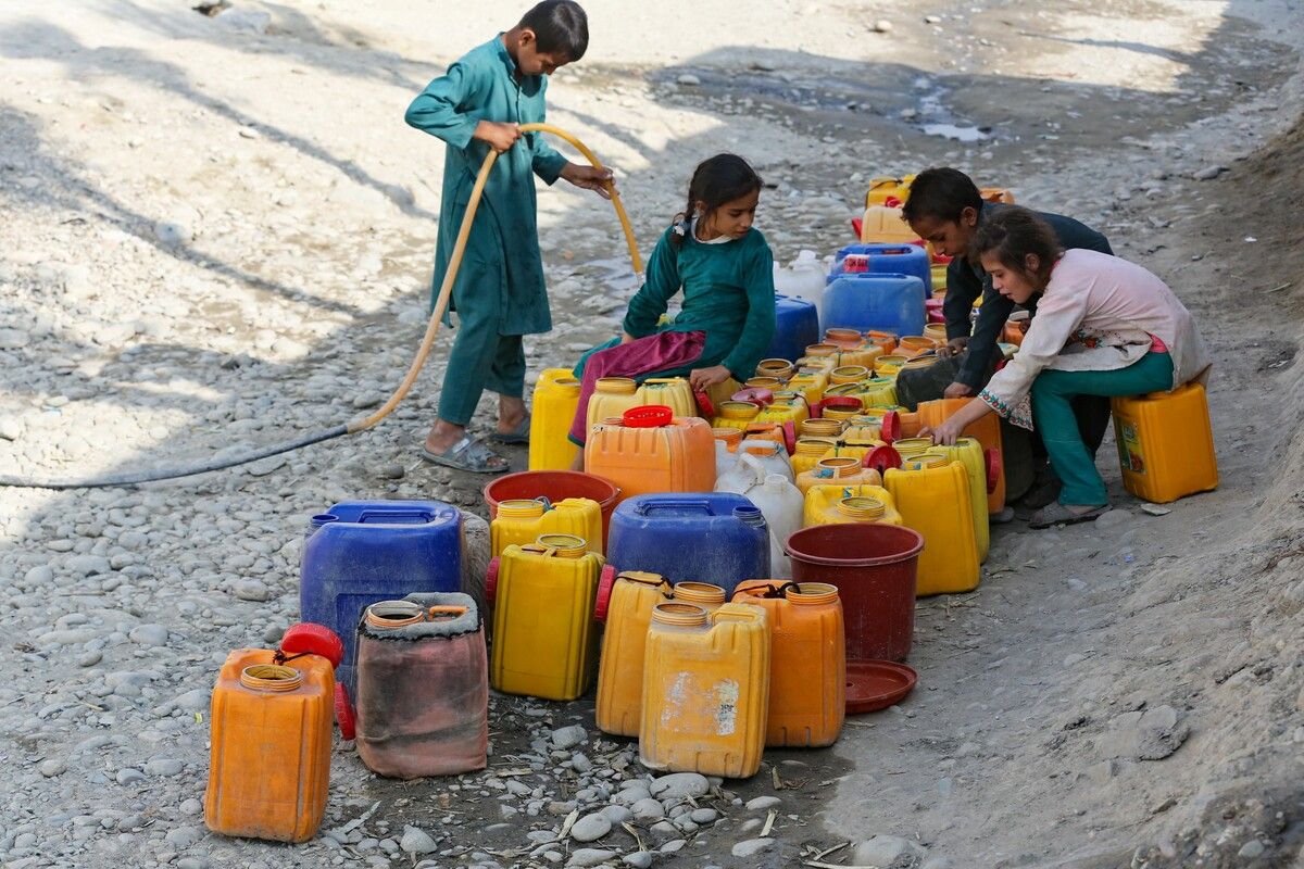 Am Rand einer Straße in Jalalabad, Afghanistan, befüllen Kinder Kanister mit Trinkwasser. AFP