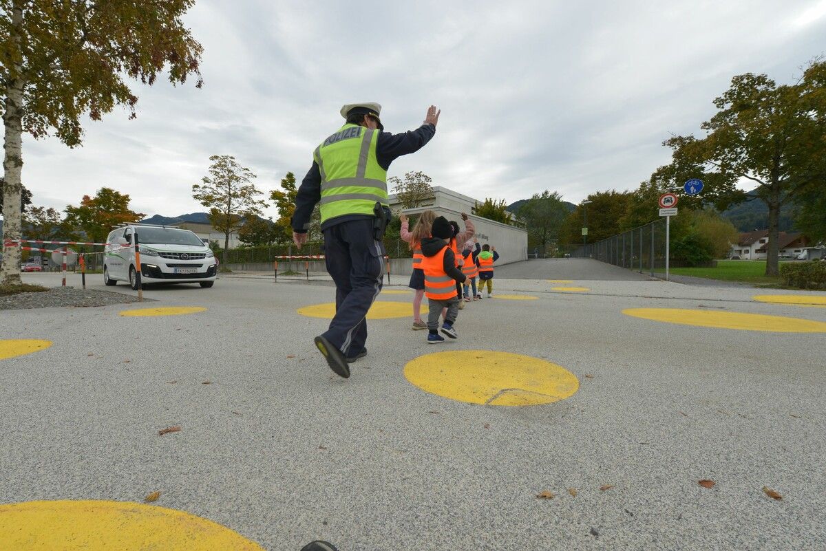 Gemeindepolizist Roland Martin mit den Kindern des Kindergartens Bifang beim Üben des Überquerens der Fahrbahn. Marktgemeinde Rankweil
