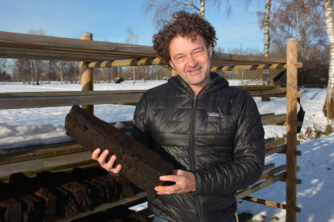Bodenexperte Walter Fitz mit einer Torfscholle im Lauteracher Ried. AFP