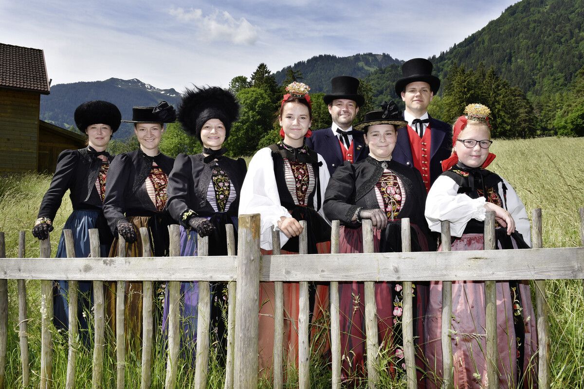 Montafonerinnen mit unterschiedlichen Kopfbedeckungen (Pelzkappa, Sanderhut, Mässli und Schäppel) mit den richtigen Überbekleidungen, dahinter zwei Männer in der Montafoner Männertracht mit Zylinder. Vorarlberger Landestrachtenverband
