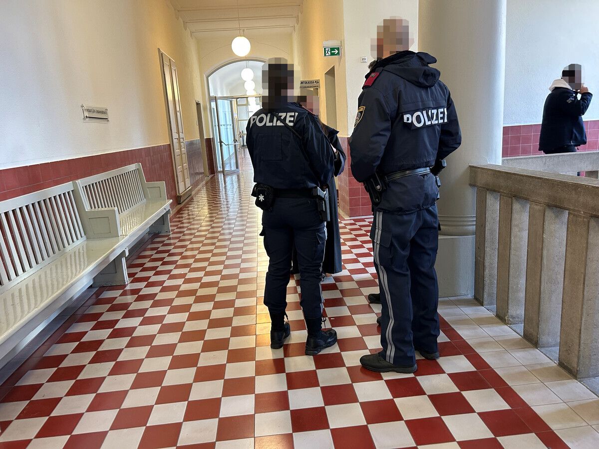 Polizeibeamte finden sich bereits während der Verhandlung vor dem Gerichtssaal ein.