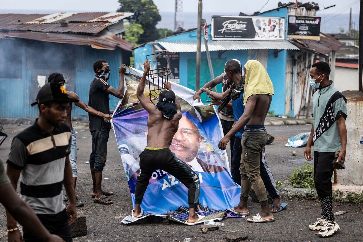 Oppositionsanhänger zerstören bei einer Demonstration in Moroni auf den Komoren ein Plakatbild des amtierenden Präsidenten Azali Assoumani. AFP