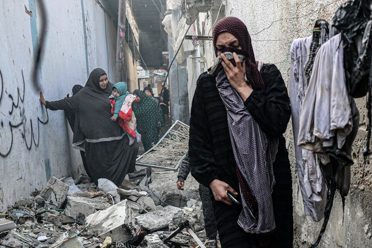Menschen bahnen sich ihren Weg durch eine mit Trümmern bedeckte Gasse nach dem nächtlichen israelischen Bombardement in Rafah im südlichen Gazastreifen. AFP