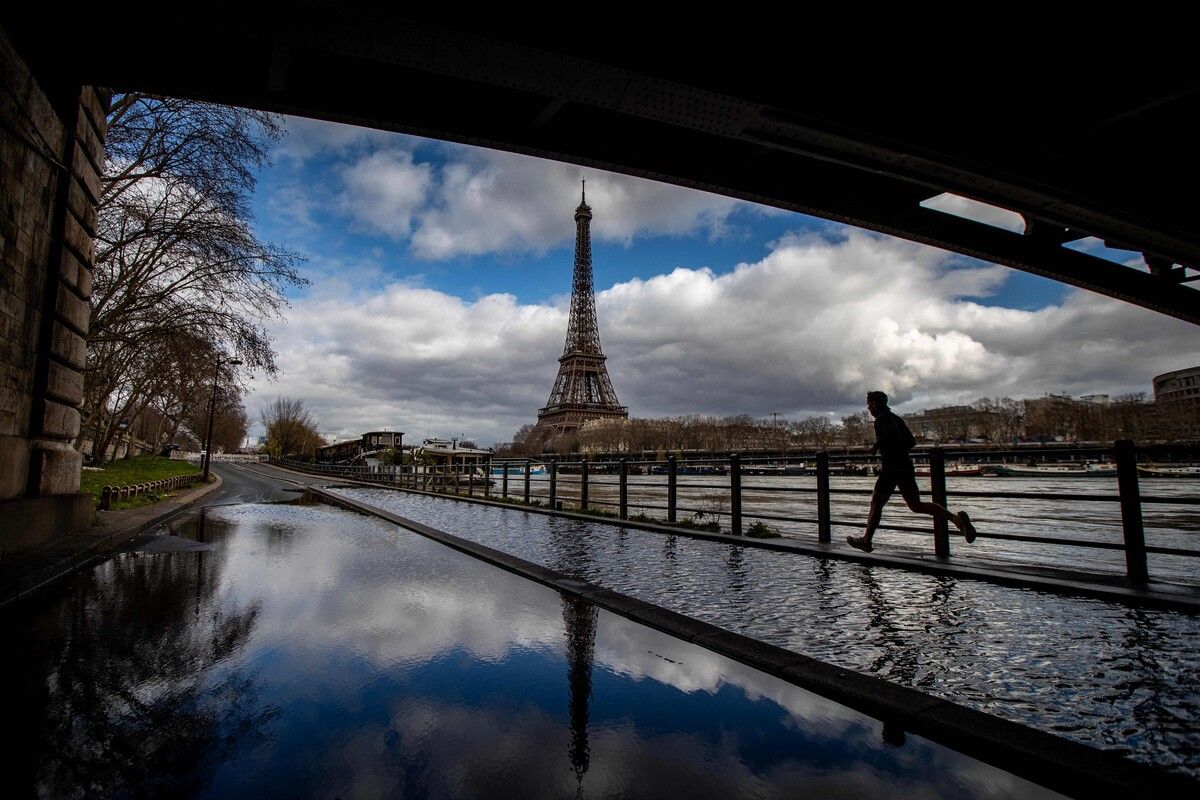 Das überflutete Ufer der Seine hält einen Jogger in Paris nicht davon ab, seine Runde mit Blick auf den Eiffelturm zu drehen. AFP