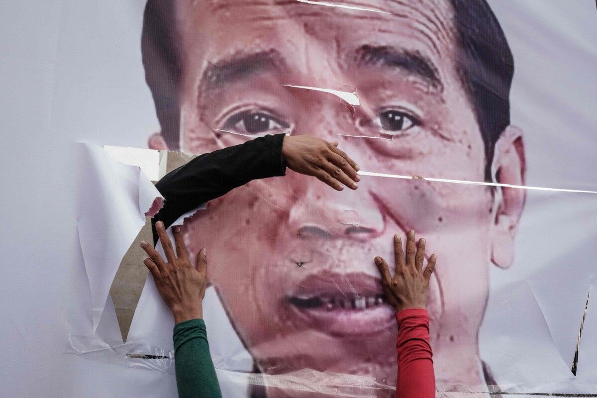 Gegendemonstranten fixieren ein zerrissenes Bannerporträt des indonesischen Präsidenten Joko Widodo. Demonstranten in Jakarta fordern die Amtsenthebung Widodos. AFP