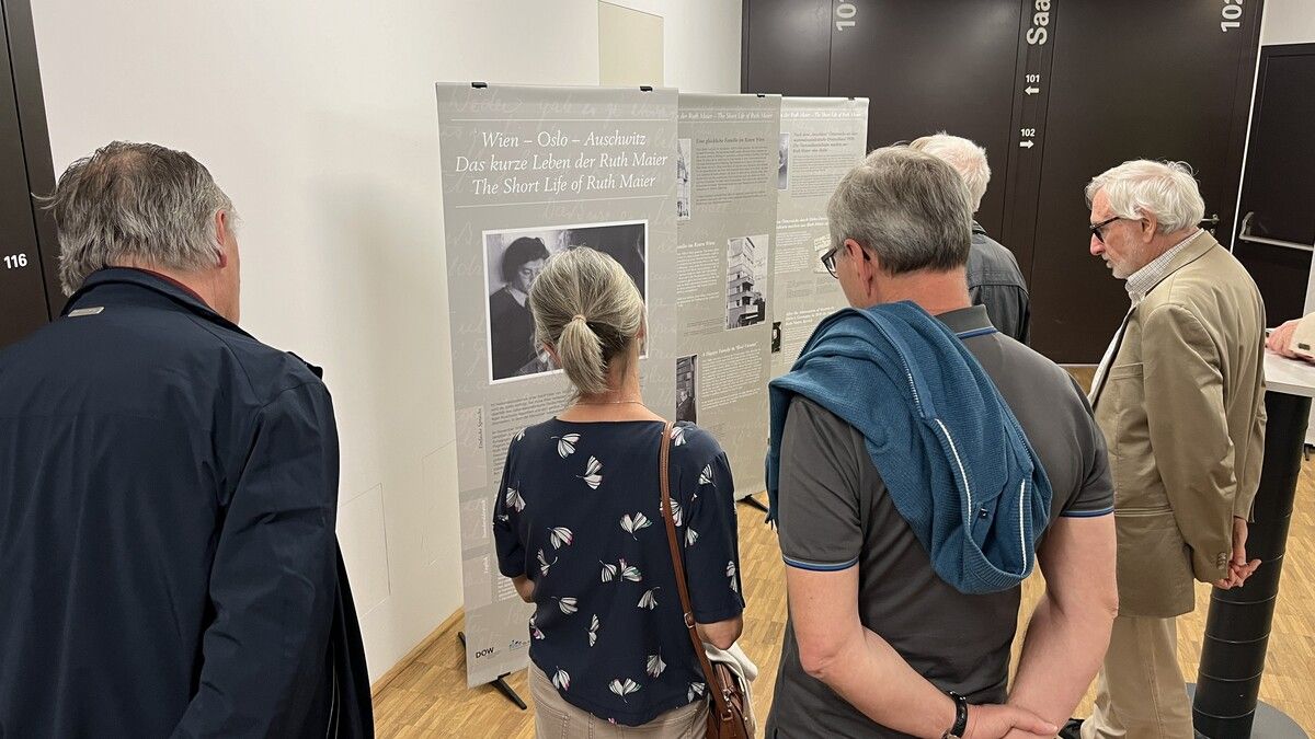 Besucher betrachten nachdenklich die informativen Tafeln der Ausstellung in der VHS Götzis.VHS GÖtzis