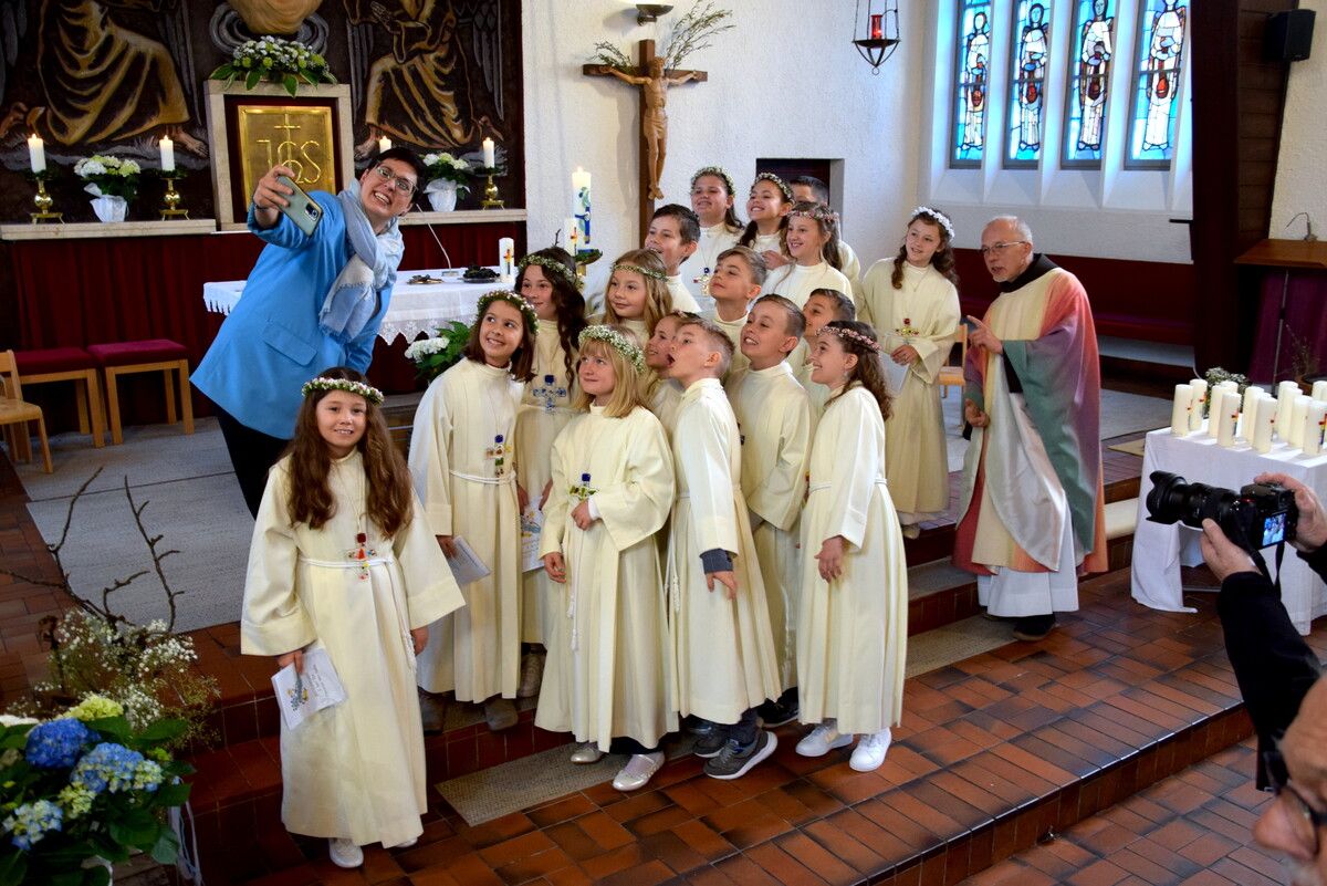Die Gemeindeleiterin der Pfarre Herz Mariae in Bludenz, Sabrina Wachter, macht im Sakralraum ein Selfie mit den Erstkommunionkindern der Pfarre.