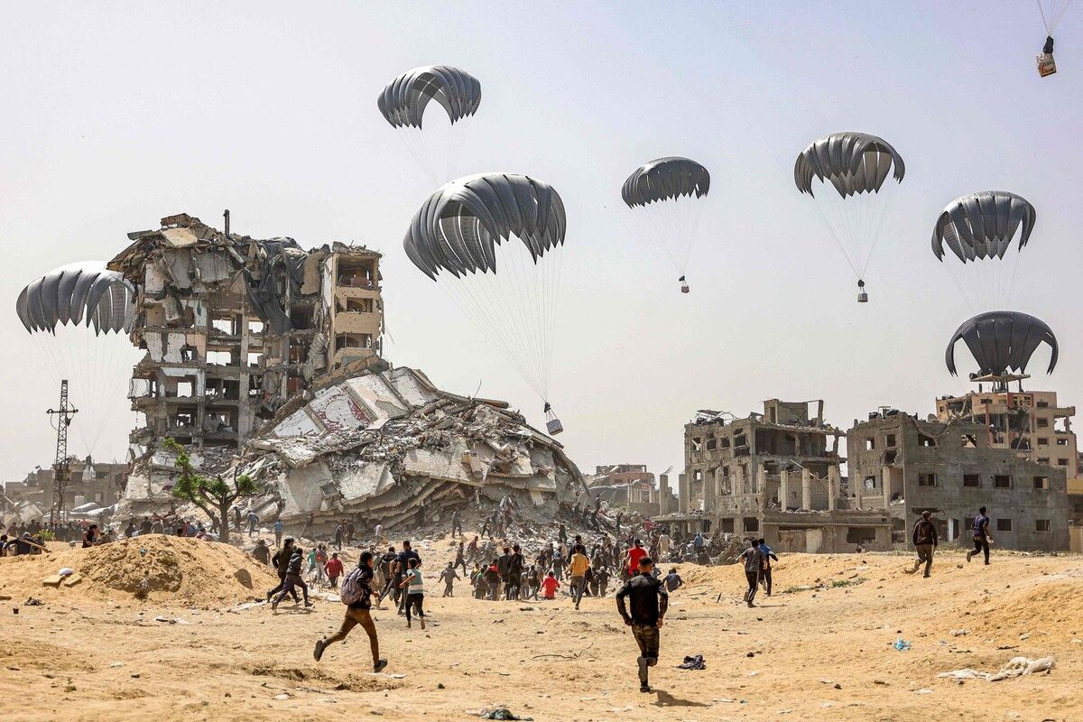 Menschen eilen zur Landung von humanitären Hilfspaketen, die über dem nördlichen Gaza-Streifen abgeworfen werden. afp