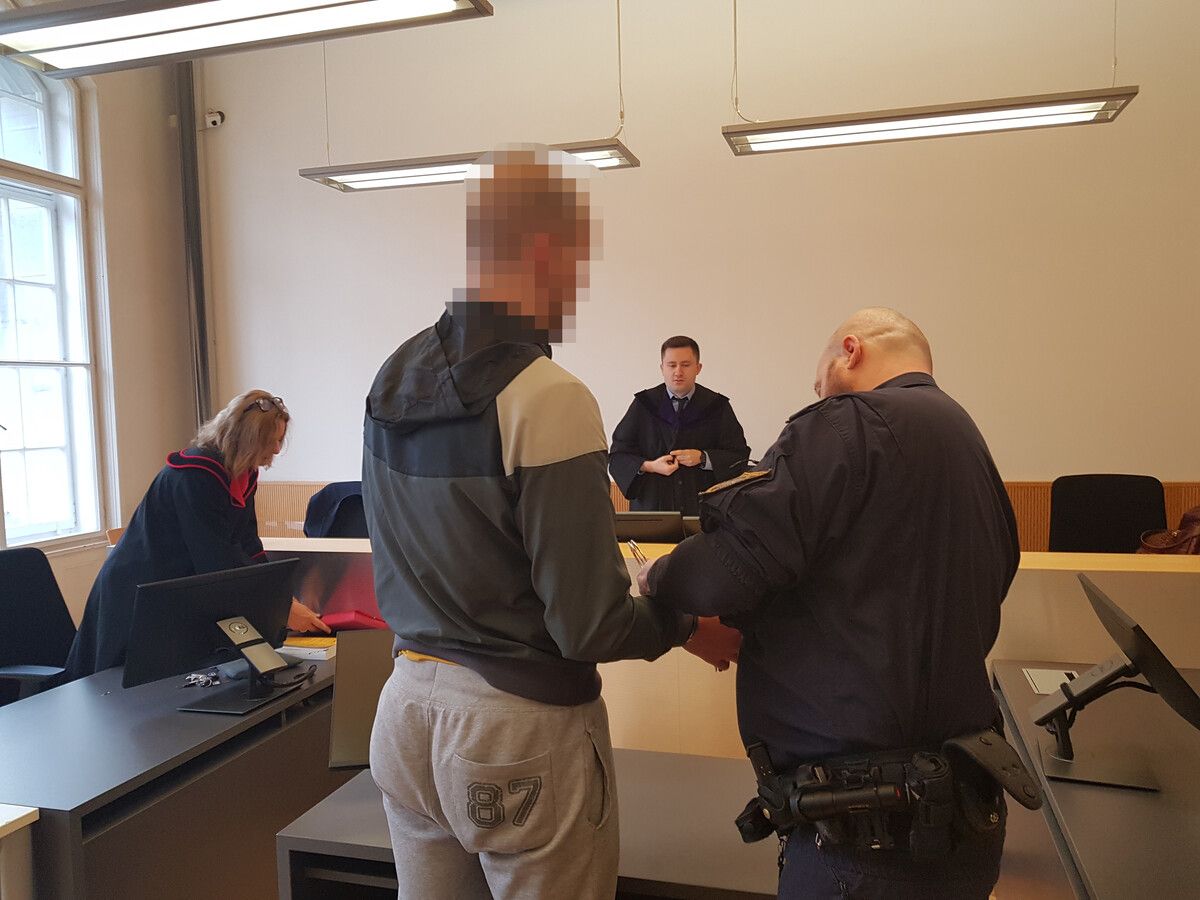 Ein Justizwachebeamter nimmt dem beschuldigten U-Häftling vor der Verhandlung die Handschellen ab. eckert