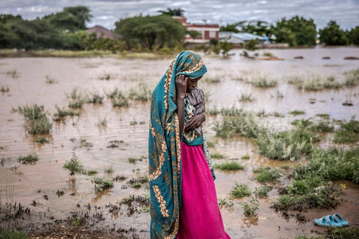 Eine Frau, die aufgrund der schweren Überflutungen ihr Zuhause verlassen musste, steht neben überschwemmtem Gebiet in Garissa, Kenia. AFP
