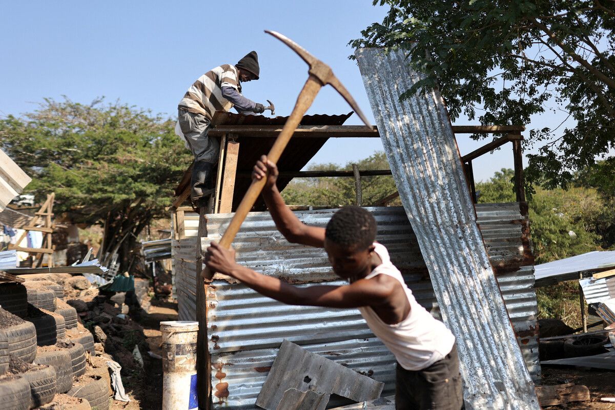 Einen Tag vor der Parlamentswahl in Südafrika, am heutigen Mittwoch, arbeiten Bewohner daran, Hütten wieder aufzubauen. REUTERS