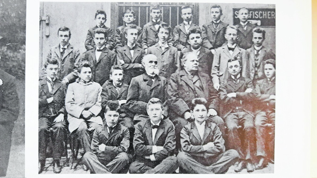 In seinem letzten Dienstjahr 1898/99 ließ sich Direktor Hackspiel mit den Klassen der Oberstufe fotografieren. Hier die Sechste mit dem späteren Dichter Franz Kafka (hinterste Reihe, 2. v.l.), Direktor Hackspiel in den Mitte mit weißem Bart. Wagenbach