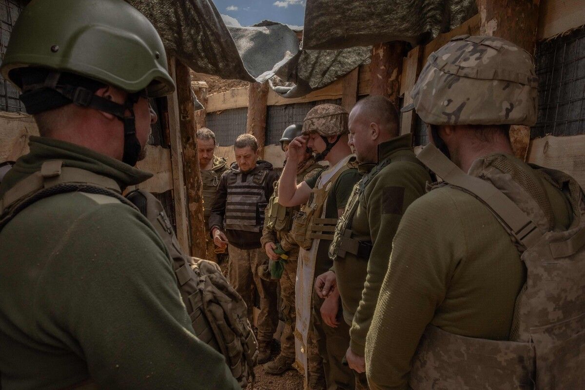 Ukrainische Soldaten beten mit einem Militärkaplan, während sie ein Schützengrabensystem in der Region Donezk vorbereiten. AFP