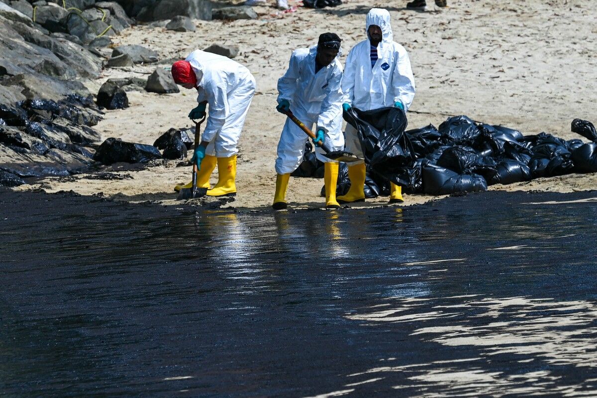 Arbeiter versuchen den Ölteppich am Tanjong Beach der Insel Sentosa in Singapur händisch zu beseitigen. AFP