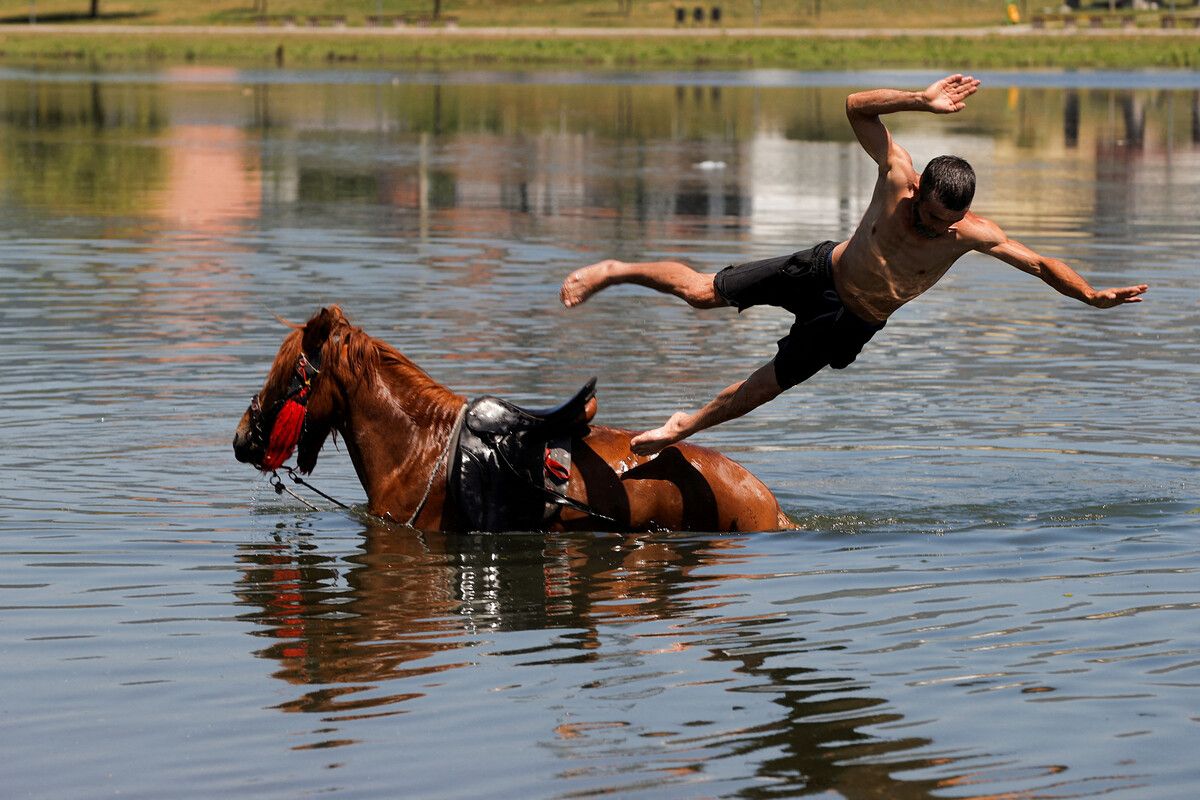 Die Hitze erreicht auch den Kosovo, wo ein Mann von einem Pferd in den Fluss Iber springt, um sich abzukühlen. RTS