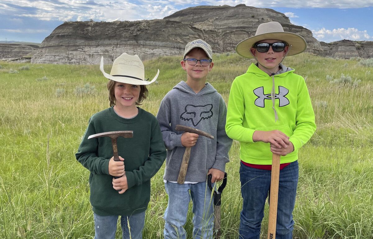 Liam Fisher, Kaiden Madsen und Jessin Fisher posieren stolz für ein Jubiläumsfoto an dem Tag, an dem ihr Fossilienfund als T. rex identifiziert wurde.  AP/Giant Screen Films