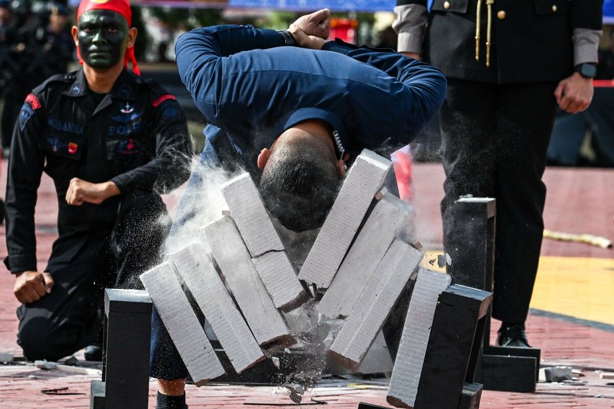 Bei der Show der Polizei in Banda Aceh in Indonesien geht ein Polizist nicht nur sprichwörtlich mit dem Kopf durch die Wand. AFP