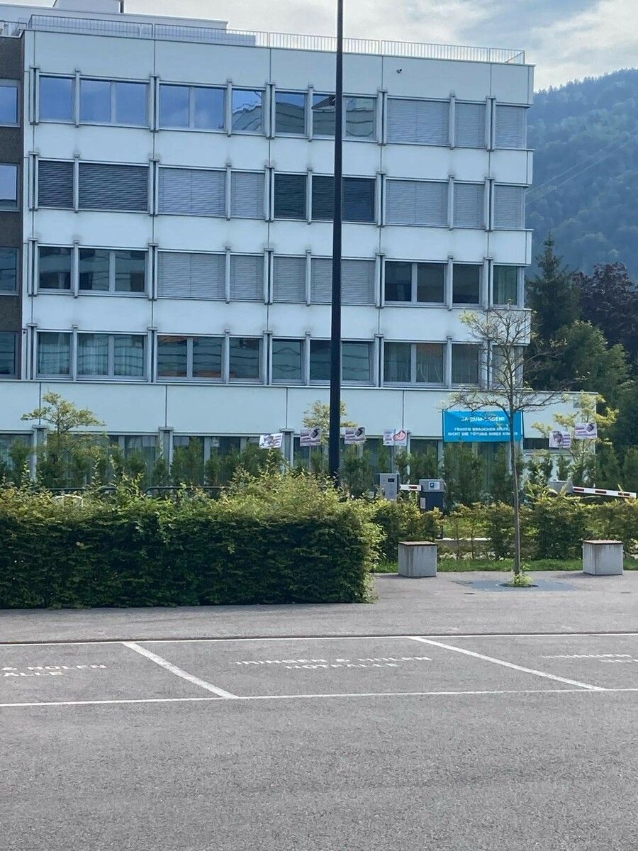 Die protestierenden Personen haben die Hecke mit einer Verlängerung ihrer Transparente überwunden.