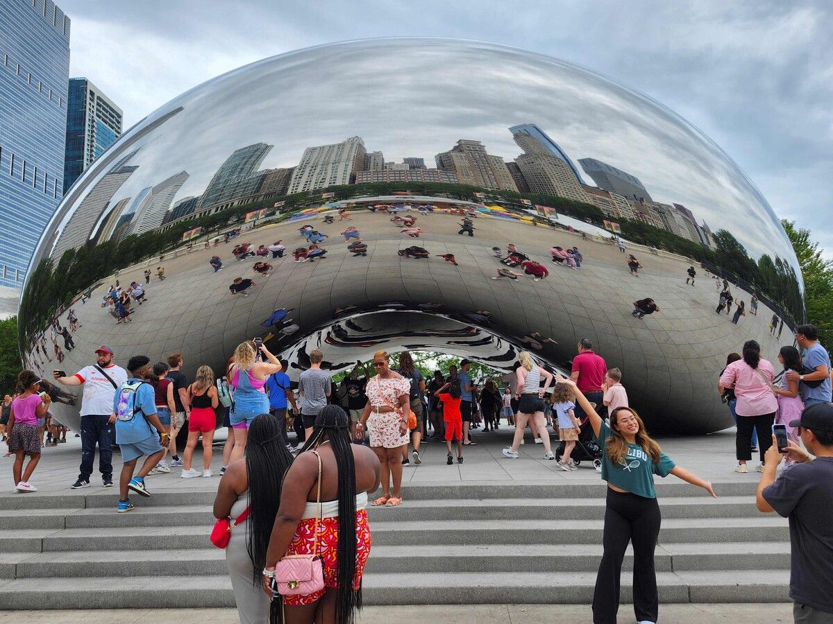 Besucher posieren für Fotos vor der Cloud-Gate-Skulptur („The Bean“), in der sich die Skyline von Chicago (Illinois, USA) widerspiegelt. AFP