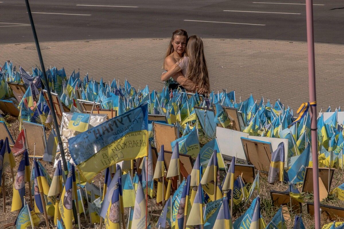 Die Ukraine feierte ihren Unabhängigkeitstag. Zwei Frauen umarmen sich an einer Gedenkstätte für gefallene Soldaten in Kiew. AFP