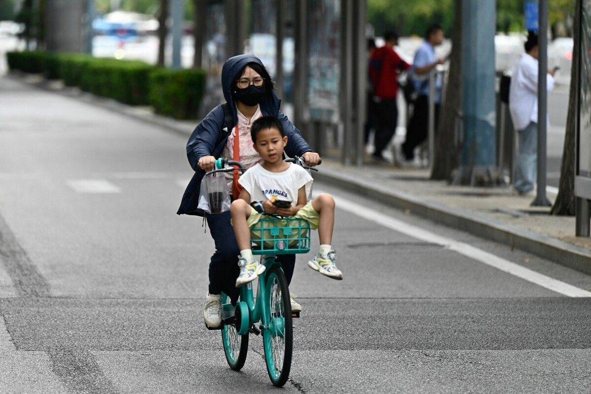 Mit dem Fahrrad durch Peking: Auch hier wird die Bevölkerung von Hitze mit über 30 Grad heimgesucht. AFP
