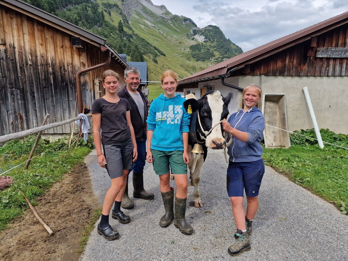 Die Jungälplerinnen Zita, Melinda und Perrine mit Alpchef Christian Kohler und der Kuh Bella.