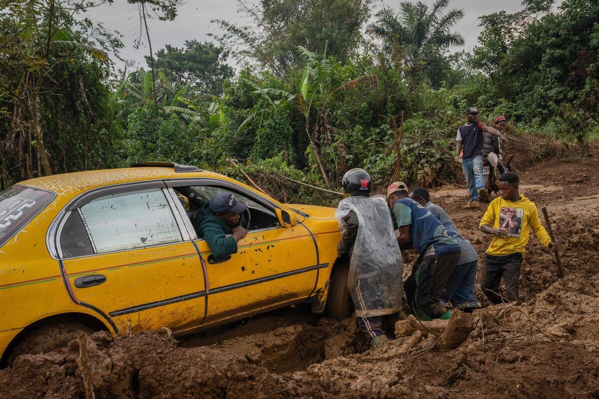 Dorfbewohner und Reisende versuchen im Osten der Demokratischen Republik Kongo ein Auto aus dem Schlamm zu befreien. AFP